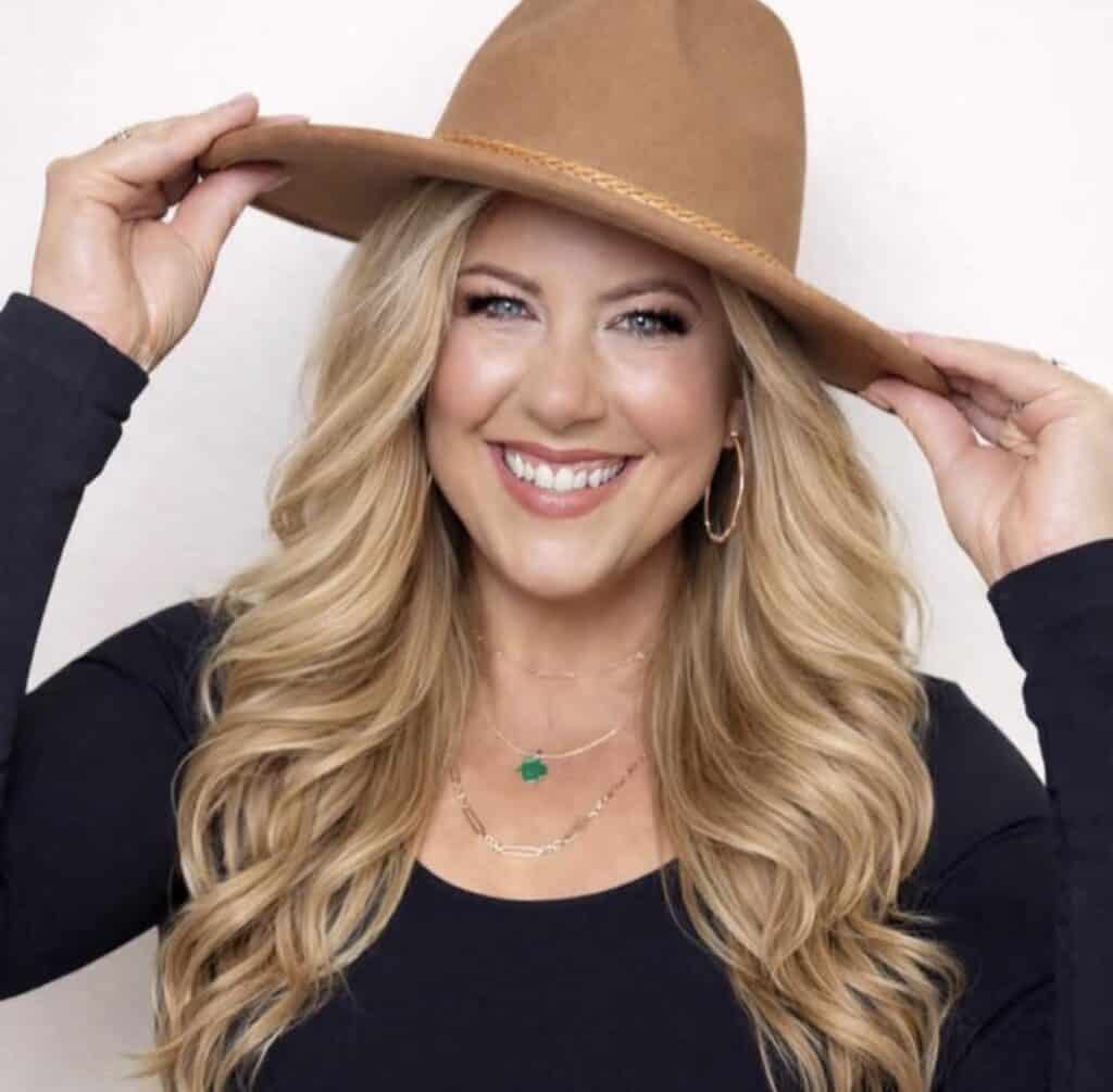 Woman smiling with wide-brim hat, modern sidebar style, fashion and lifestyle image.