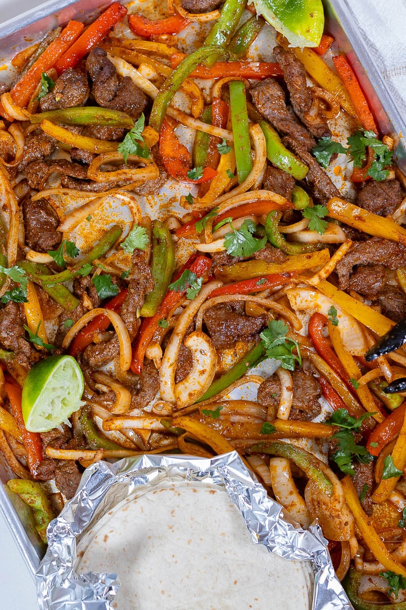 Sheet pan steak fajitas made with tender skirt steak, colorful bell peppers, and onions roasted until lightly charred and served with warm tortillas for an easy weeknight Tex-Mex dinner.