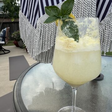 A refreshing Limoncello Spritz made with creamy limoncello, prosecco, and club soda, garnished with fresh mint and a lemon slice over ice.