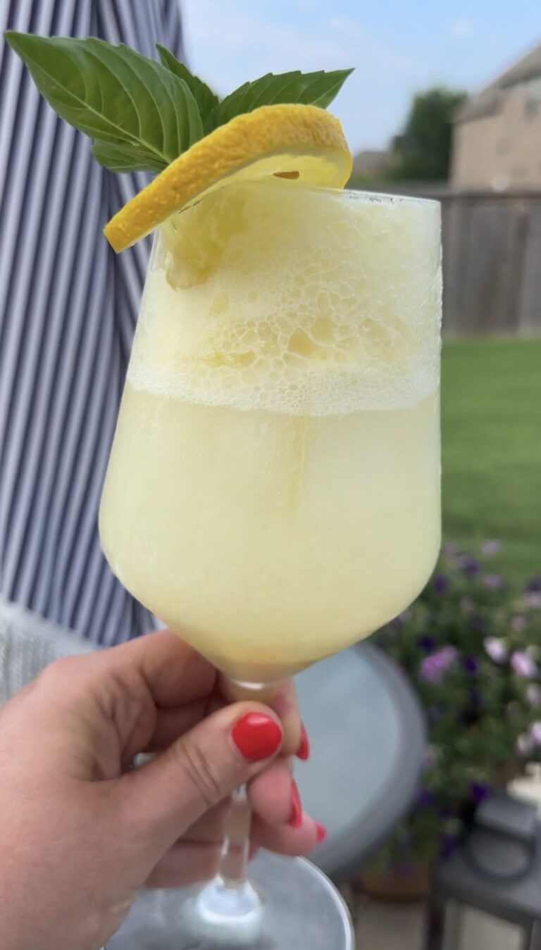 A refreshing Limoncello Spritz made with creamy limoncello, prosecco, and club soda, garnished with fresh mint and a lemon slice over ice.