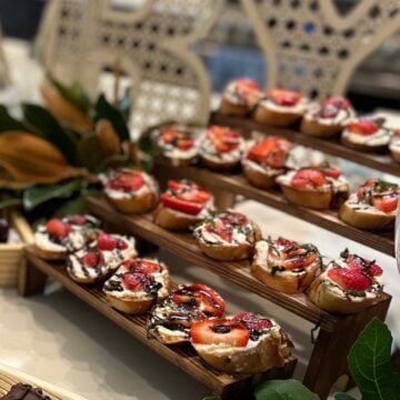 Strawberry balsamic crostini topped with whipped honey goat cheese, fresh marinated strawberries, chopped mint, and balsamic glaze on toasted baguette slices.