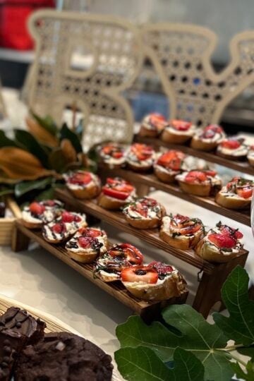 Strawberry balsamic crostini topped with whipped honey goat cheese, fresh marinated strawberries, chopped mint, and balsamic glaze on toasted baguette slices.