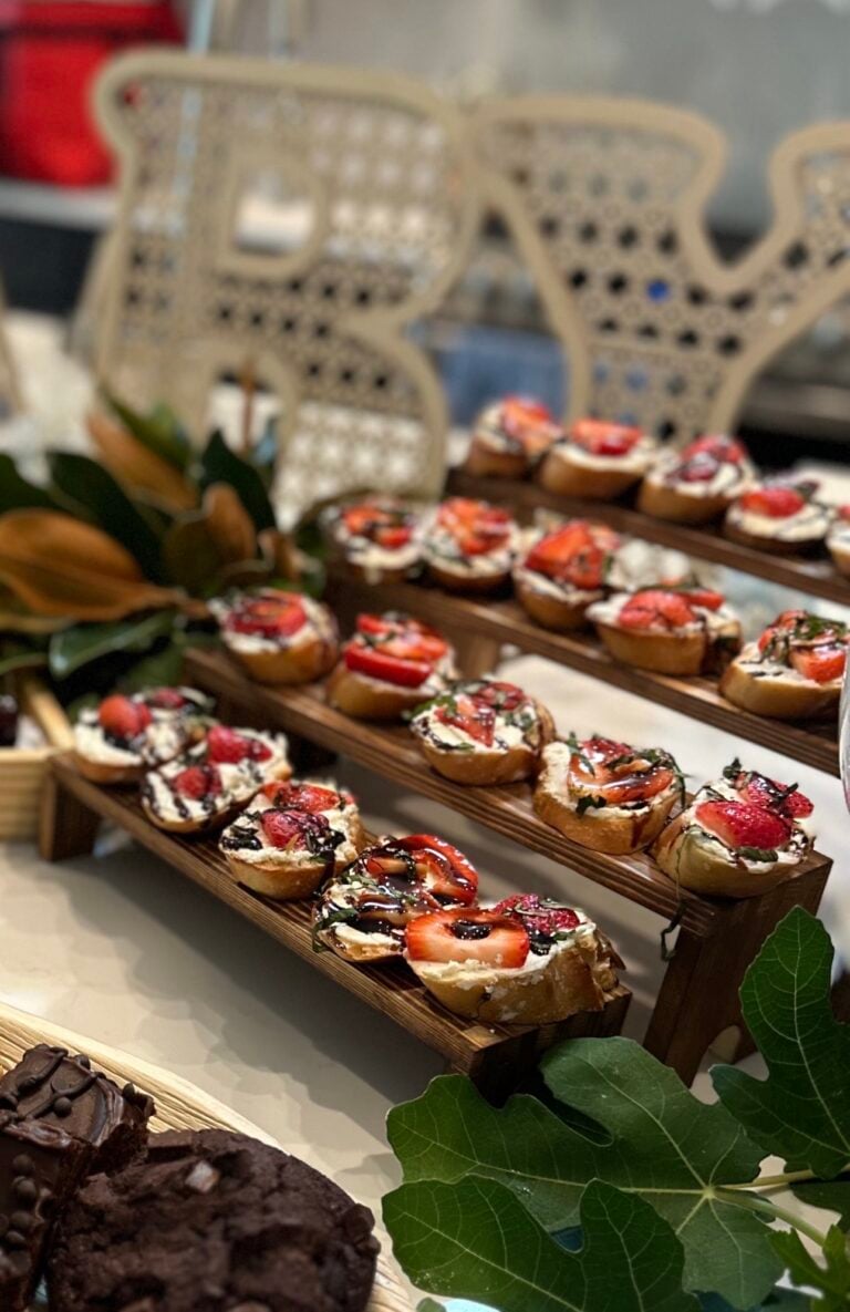 Strawberry balsamic crostini topped with whipped honey goat cheese, fresh marinated strawberries, chopped mint, and balsamic glaze on toasted baguette slices.