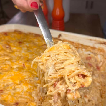 Creamy Chicken Spaghetti with Boursin Cheese baked with shredded chicken, cheddar cheese, and sautéed vegetables in a casserole dish.