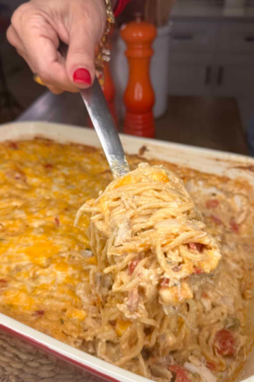 Creamy Chicken Spaghetti with Boursin Cheese baked with shredded chicken, cheddar cheese, and sautéed vegetables in a casserole dish.