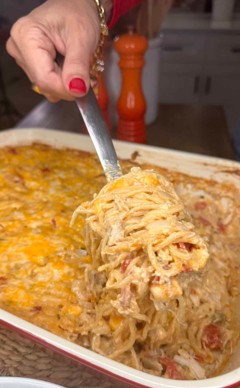 Creamy Chicken Spaghetti with Boursin Cheese baked with shredded chicken, cheddar cheese, and sautéed vegetables in a casserole dish.