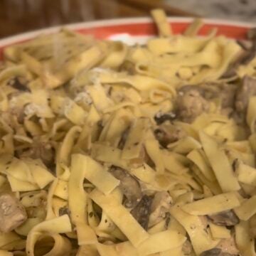 Creamy Boursin Chicken Stroganoff served over egg noodles with mushrooms and fresh parsley.