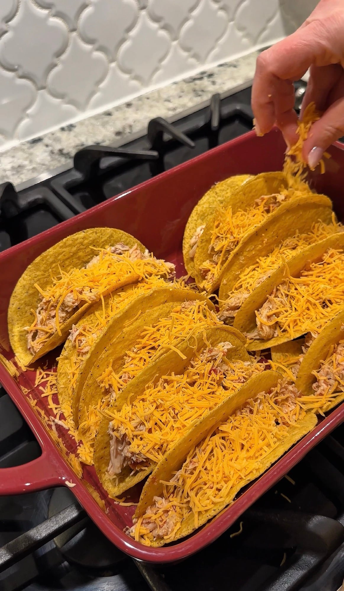 These Salsa Chicken Baked Tacos are the perfect easy family dinner. Slow cooker salsa chicken is tucked into crunchy taco shells, topped with shredded cheese, and baked until crispy before being finished with fresh lettuce, tomatoes, avocado, sour cream, and your favorite taco toppings. This simple recipe is perfect for busy weeknights and meal prep since the salsa chicken can be used in tacos, nachos, quesadillas, burrito bowls, and more throughout the week.