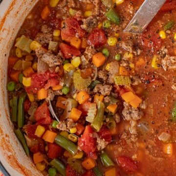 Bowl of hearty veggie beef soup made with ground beef, vegetables, and V8 tomato juice