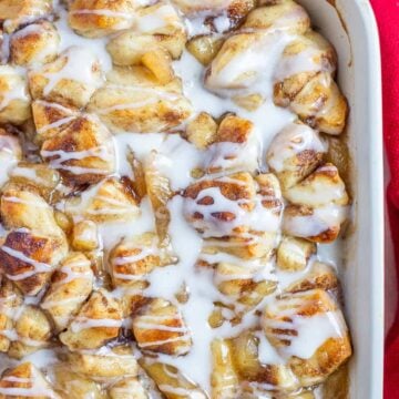 2-ingredient apple cobbler made with apple pie filling and cinnamon rolls, baked until golden and topped with cinnamon roll icing