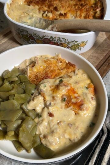 Neiman Marcus chicken casserole in a white 9x13 dish with a golden Ritz cracker topping and crumbled bacon