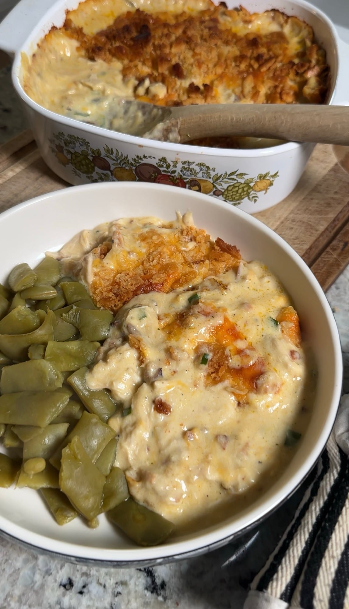 Neiman Marcus chicken casserole in a white 9x13 dish with a golden Ritz cracker topping and crumbled bacon