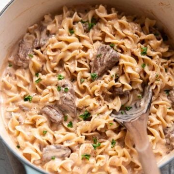 Quick beef stroganoff with chuck roast served over wide egg noodles in a skillet