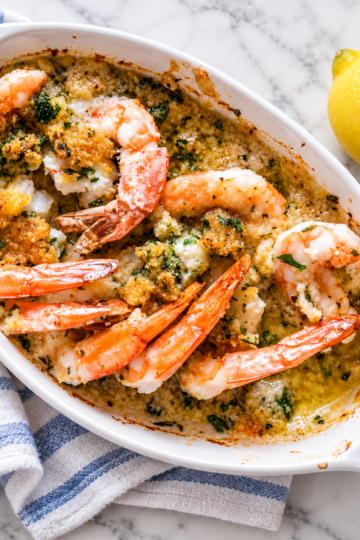 Baked shrimp oreganata topped with Parmesan panko breadcrumbs and fresh parsley, served with lemon wedges