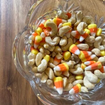Candy corn and lightly salted cashews mixed together in a serving bowl.
